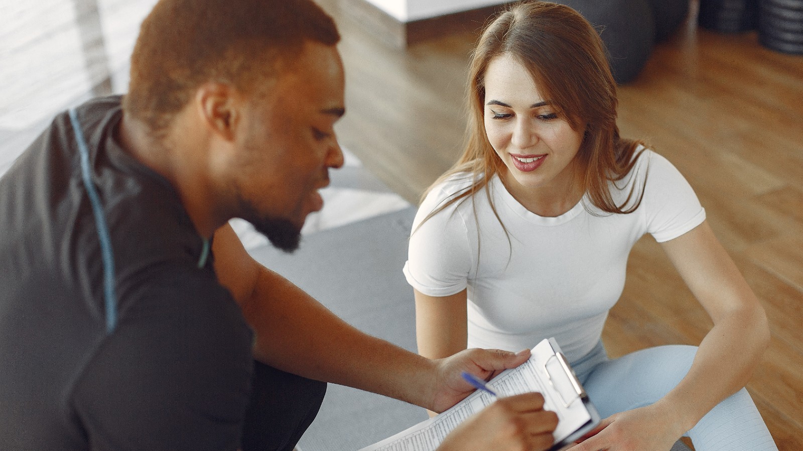 Fitness professional completing a questionnaire with a client